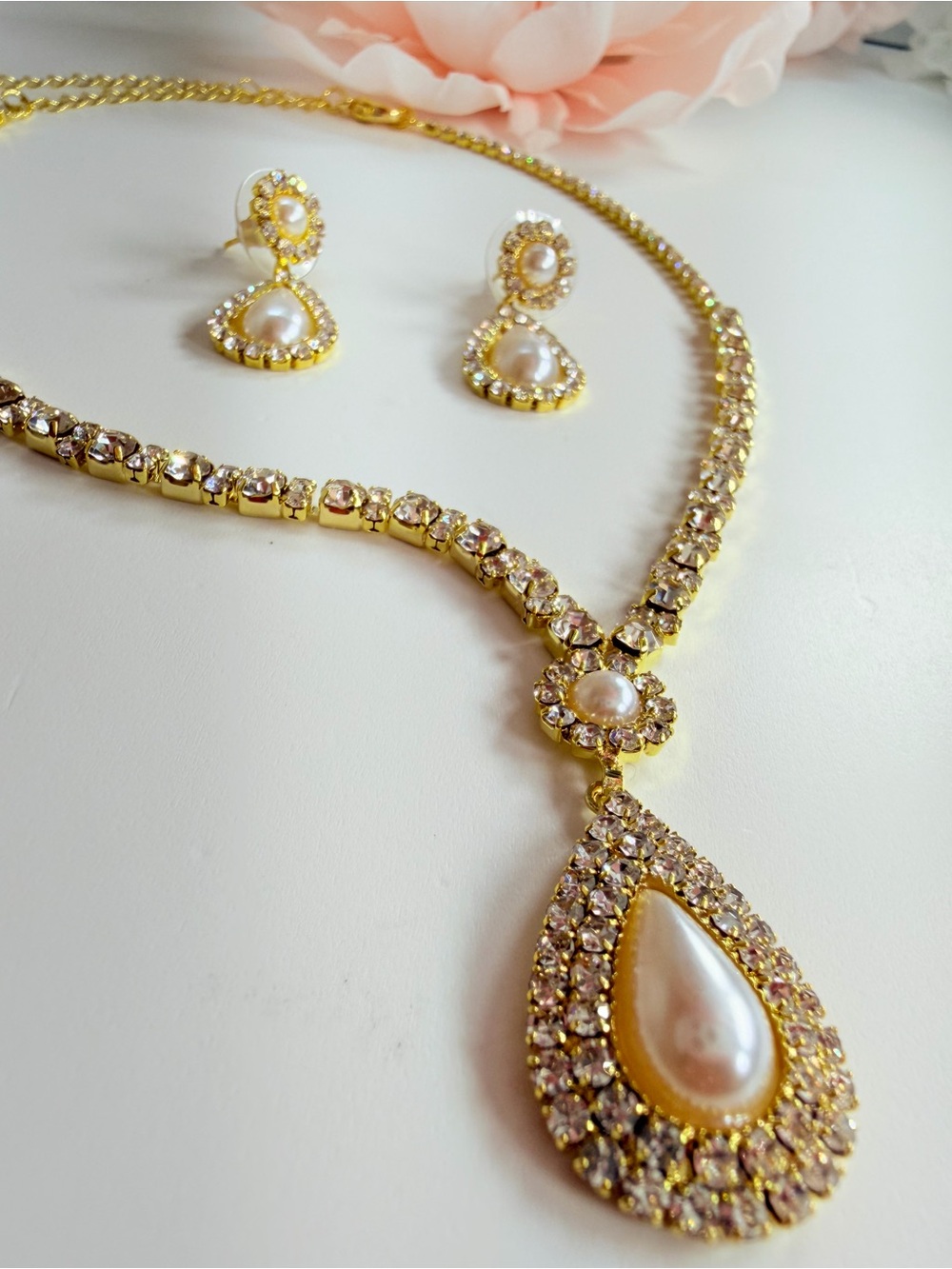 Elegant gold-tone necklace with earrings featuring a white teardrop pearl pendan